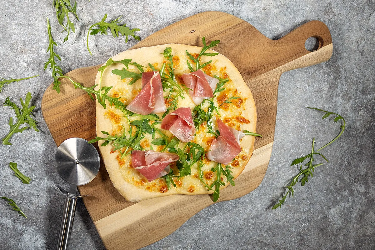 Pizza bianca met witte saus, ham en rucola