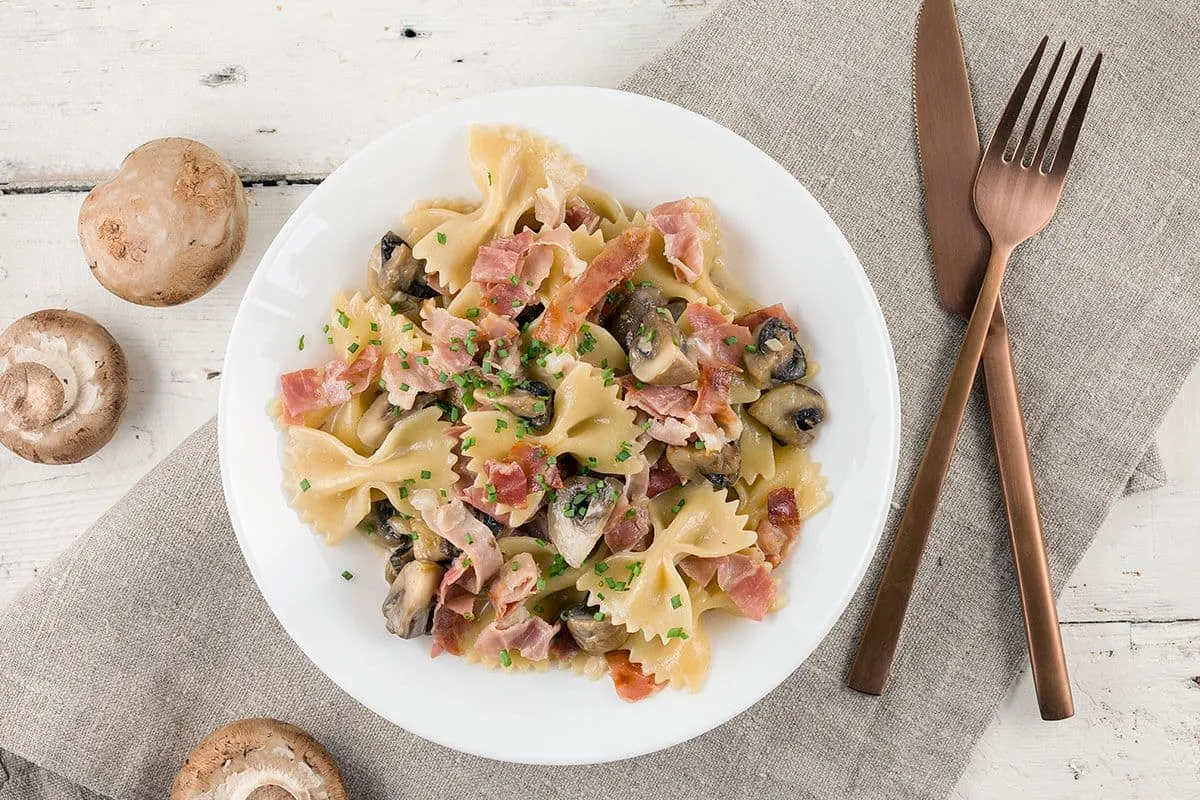 Romige farfalle met champignons en ham