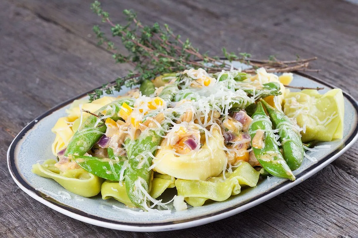 Twee kleuren tortellini met manchego en peultjes