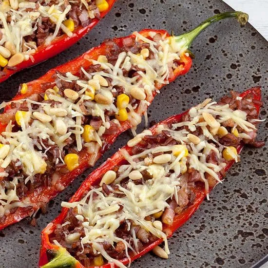 Recept: Gevulde puntpaprika's met rode rijst en spekjes